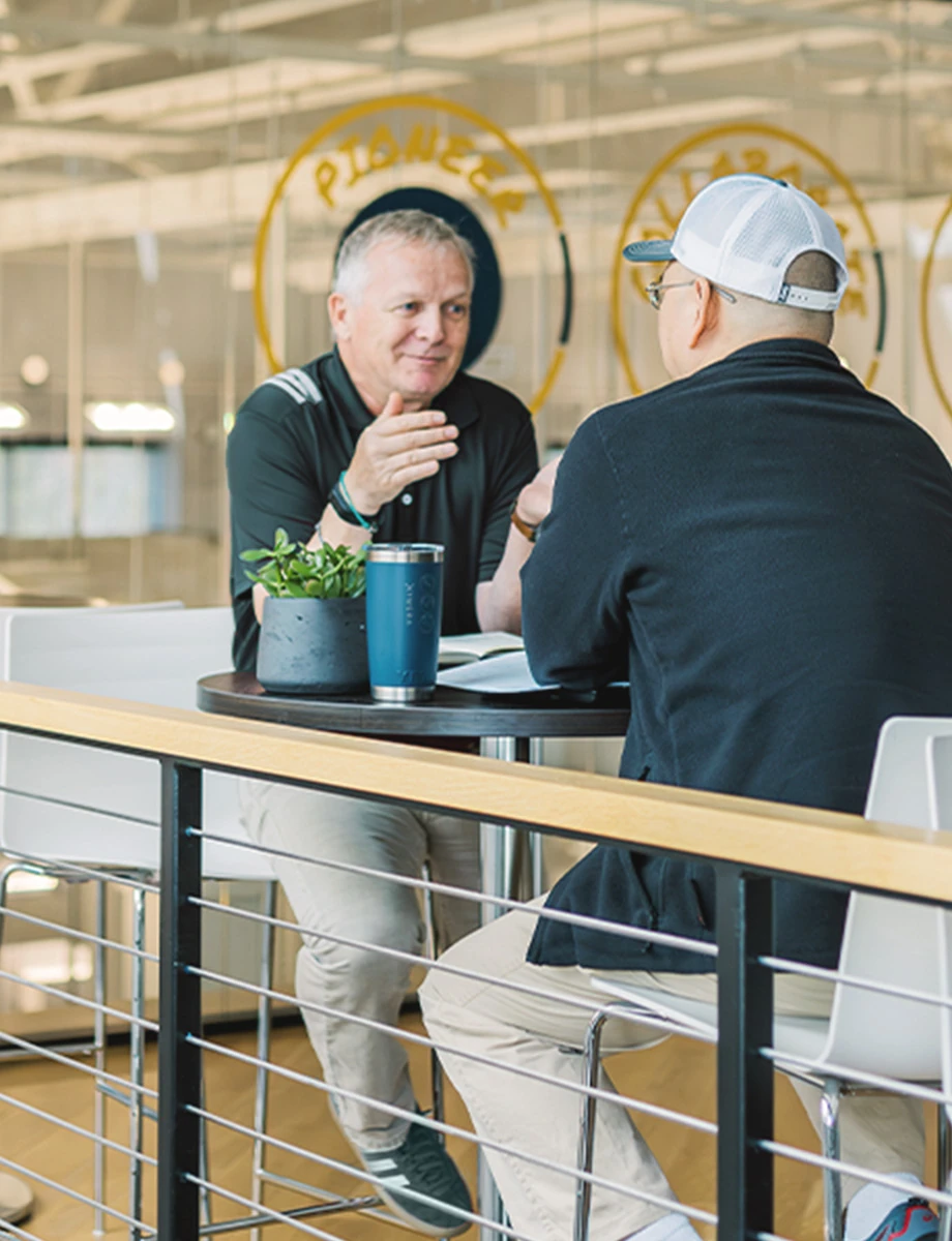 Kymera employees converse in a cafeteria setting